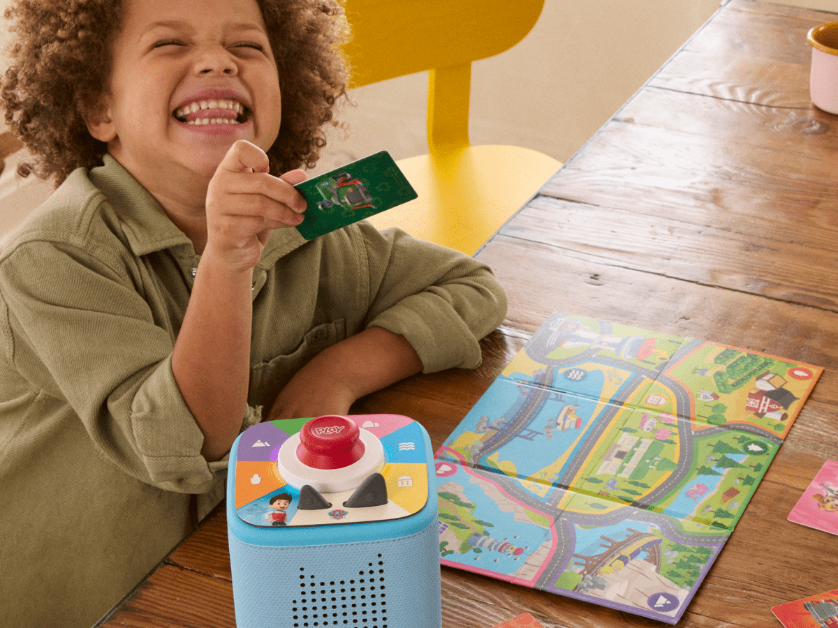 child playing with Paw Patrol: Adventure Bay Rescue Heroes - ToniePlay Game and map with a blue toniebox 2