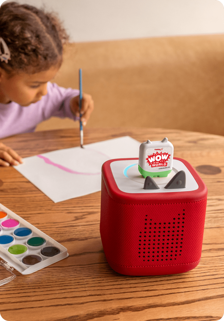 child enjoying craft time while listening to wow in the world tonie on a red toniebox 2