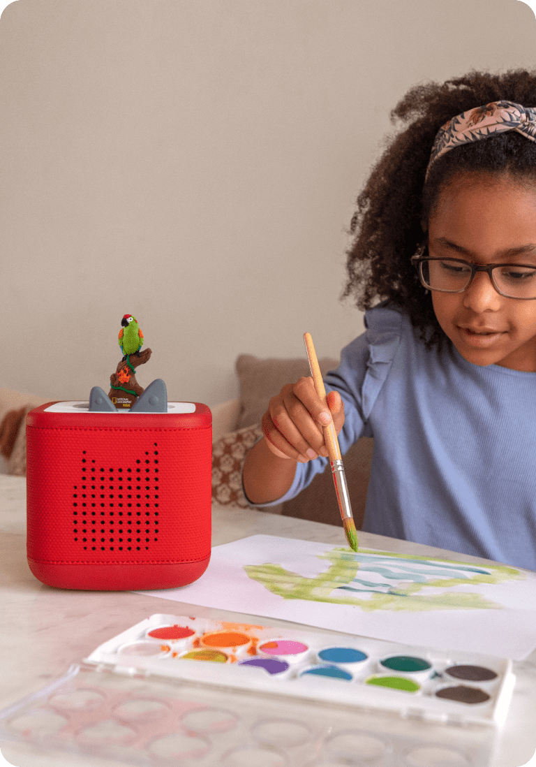 child enjoying craft time while listening to rainforest tonie on a red toniebox 2
