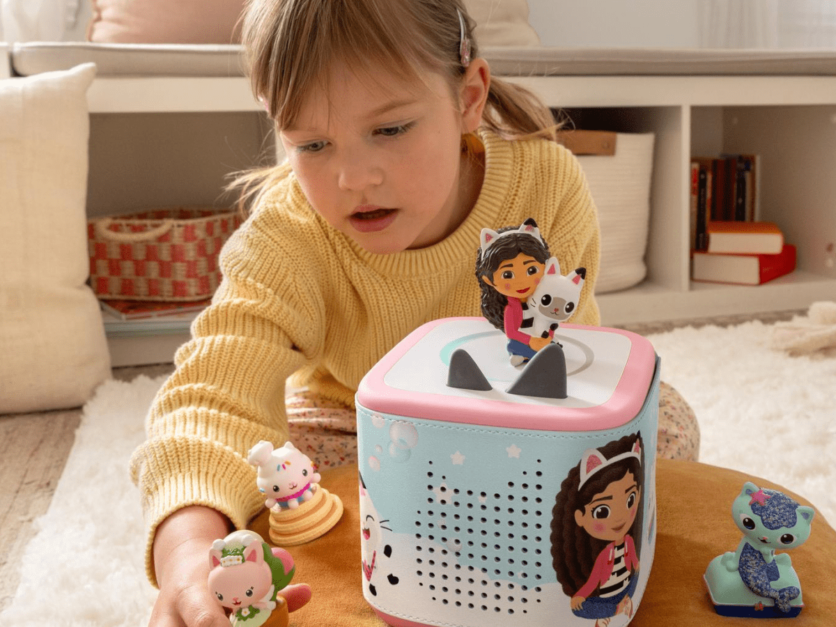 Child playing with a pink Toniebox 2 and Gabby's Dollhouse Tonies in a Gabby's Dollhouse Sleeve