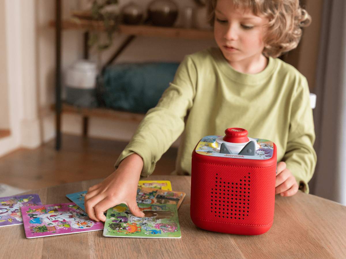 Child playing with a red Toniebox 2 an audio player for kids with monster talent search tonieplay