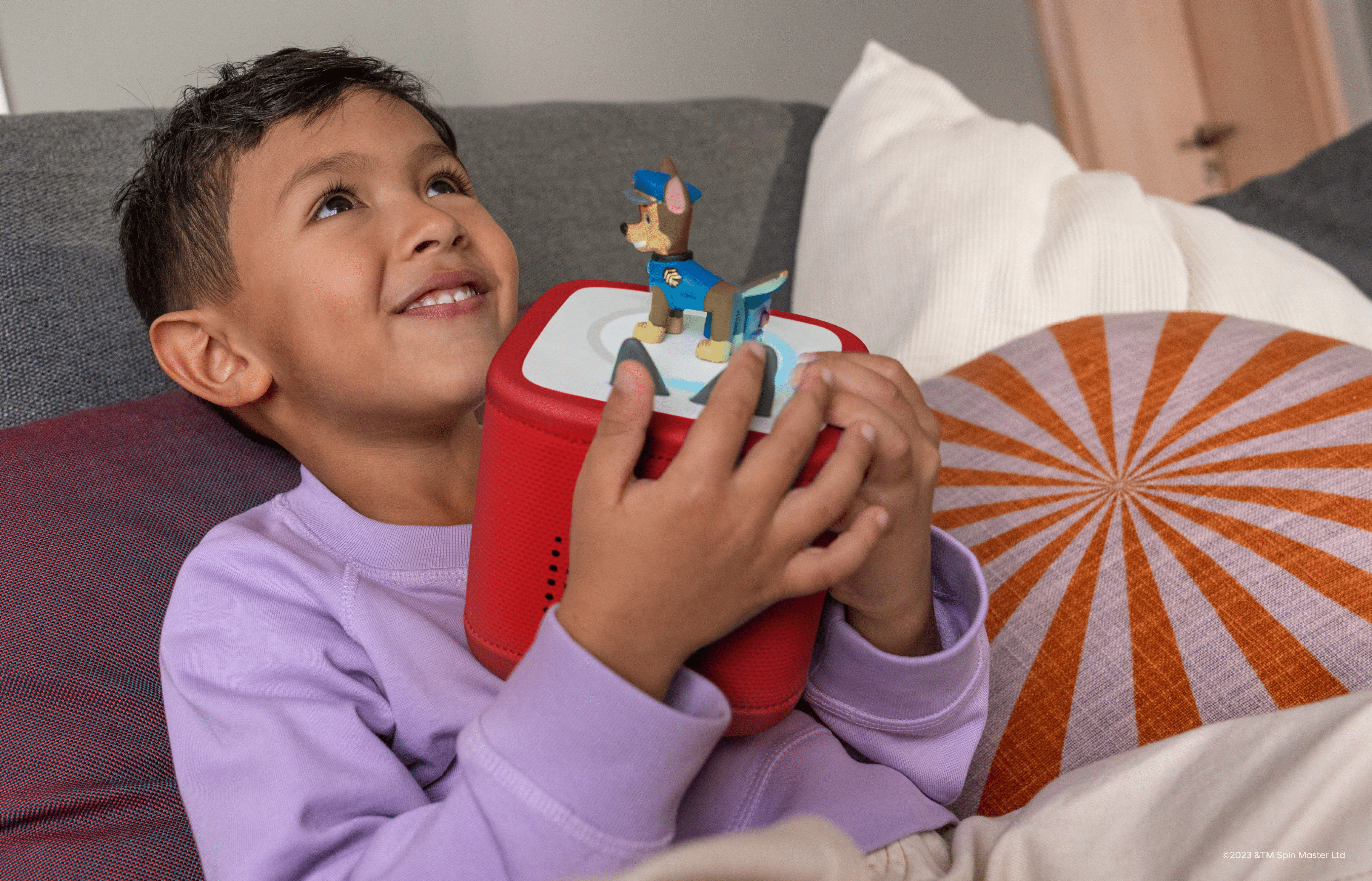 child listening to Chase Tonie on a red Toniebox 2