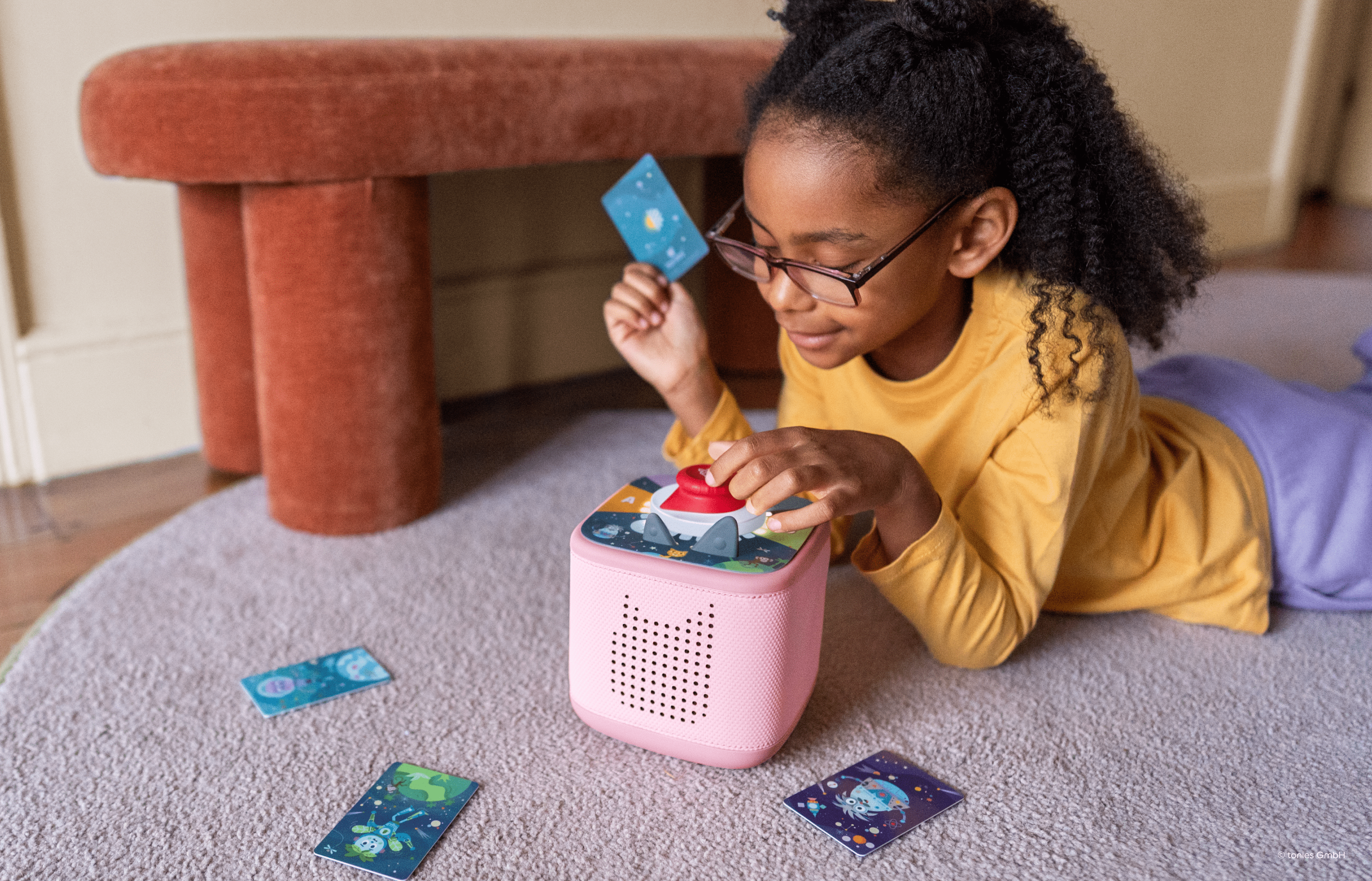 girl playing Tonieplay game with controller and pink Toniebox 2