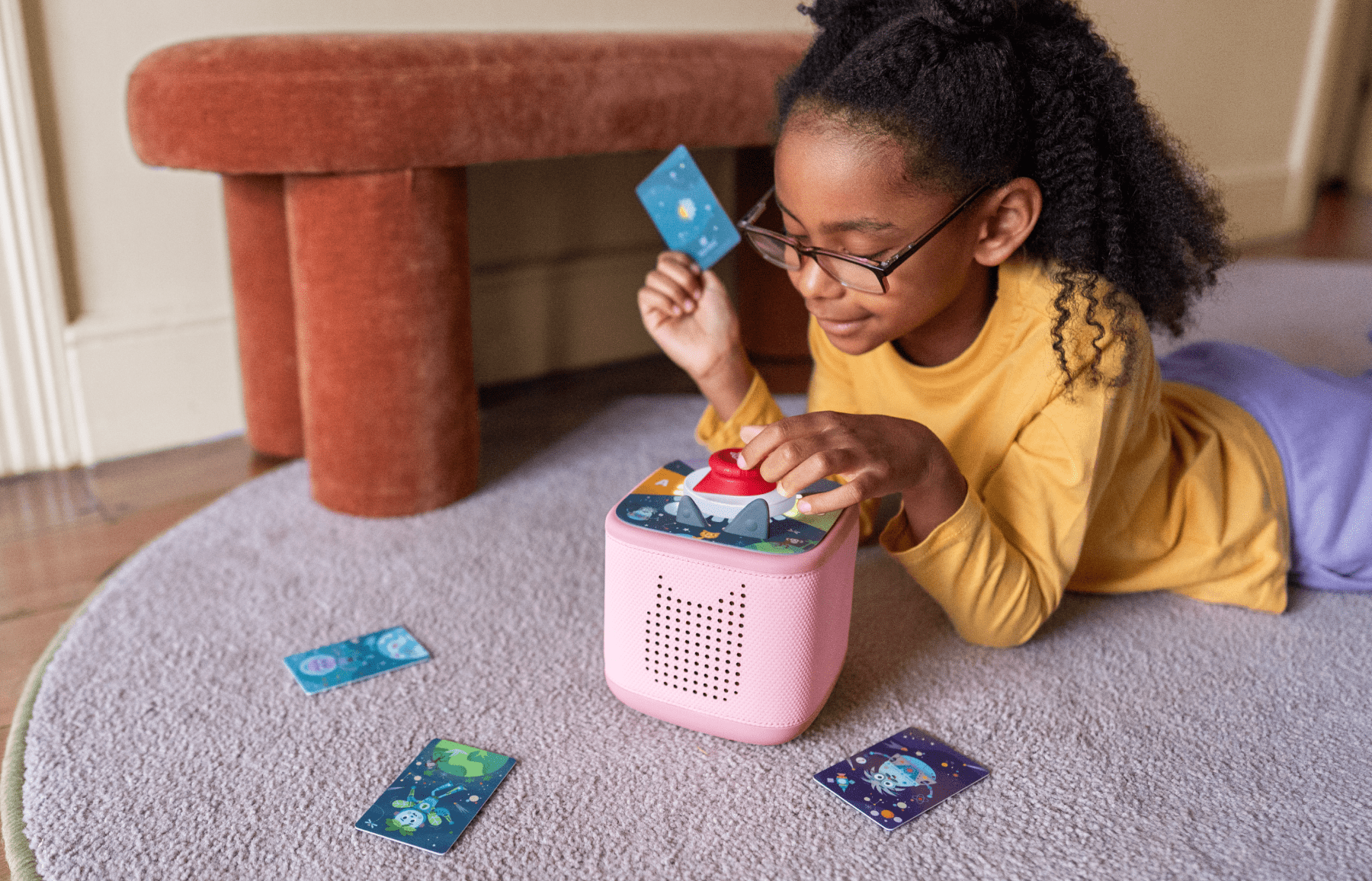 girl playing Tonieplay game with controller and pink Toniebox 2