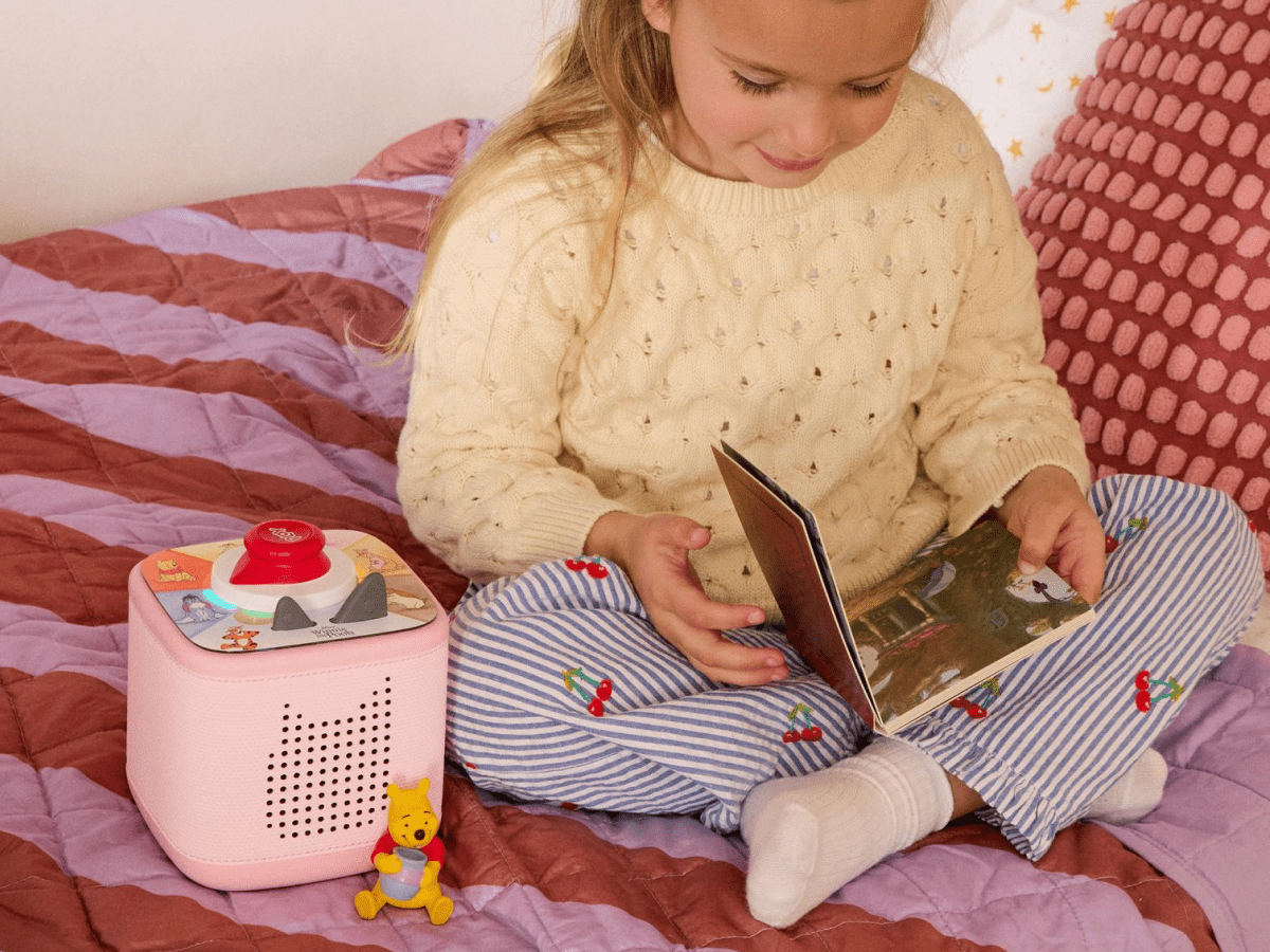 child playing with Toniebox 2 an audio player for kids with Winnie the Pooh Tonie audio figurine and Winnie the Pooh Tiggers Mixup Fixup Tonieplay Game