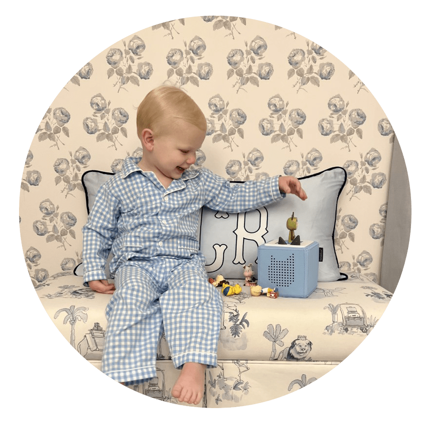Young child in pajamas playing with Toniebox and Tonies