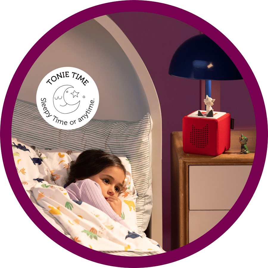 young girl in bed with a red Toniebox on her night stand