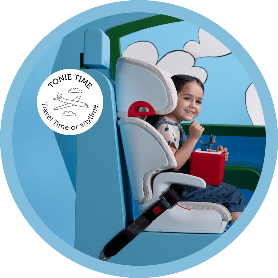 young girl in a carseat with her Toniebox and a Tonie