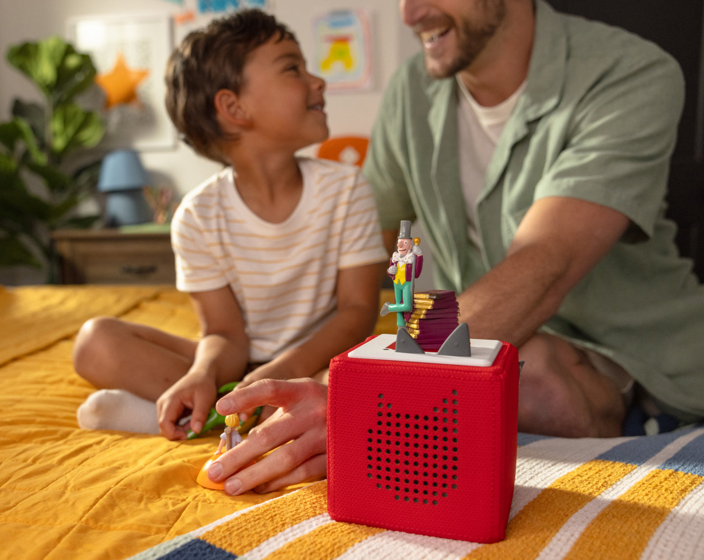 child and adult playing with tonies and a red toniebox