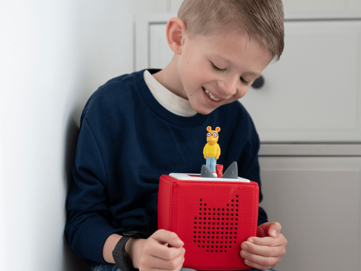 Child playing with Arthur Tonie audio figurine and Toniebox 2