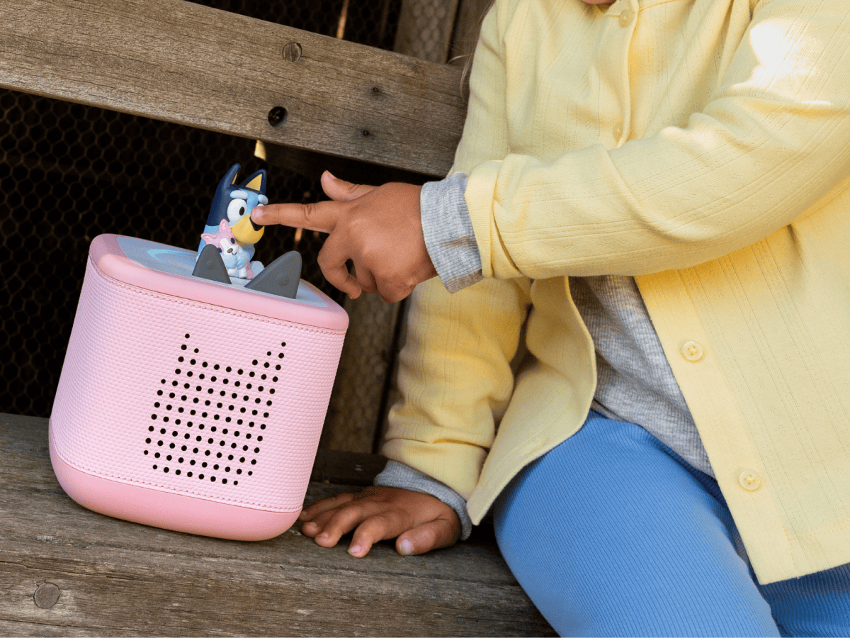 child playing with a pink toniebox 2 and a bluey tonie audio figurine for kids