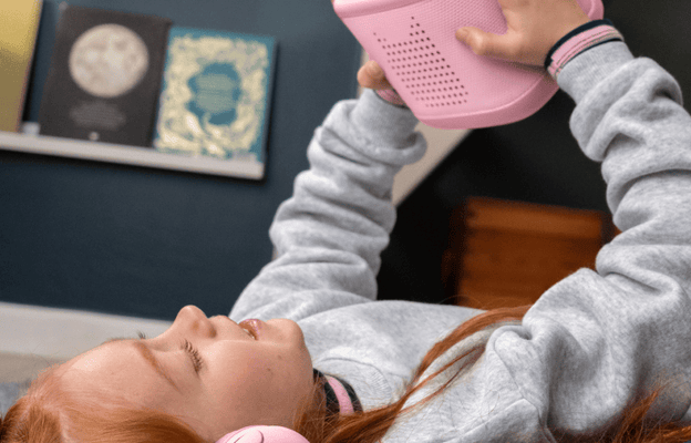 child wearing pink tonies bluetooth headphones while listening to a Creative Tonie of the Toniebox 2