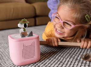 Child playing with Peanuts Camp Snoopy Tonie audio figurine and Toniebox 2