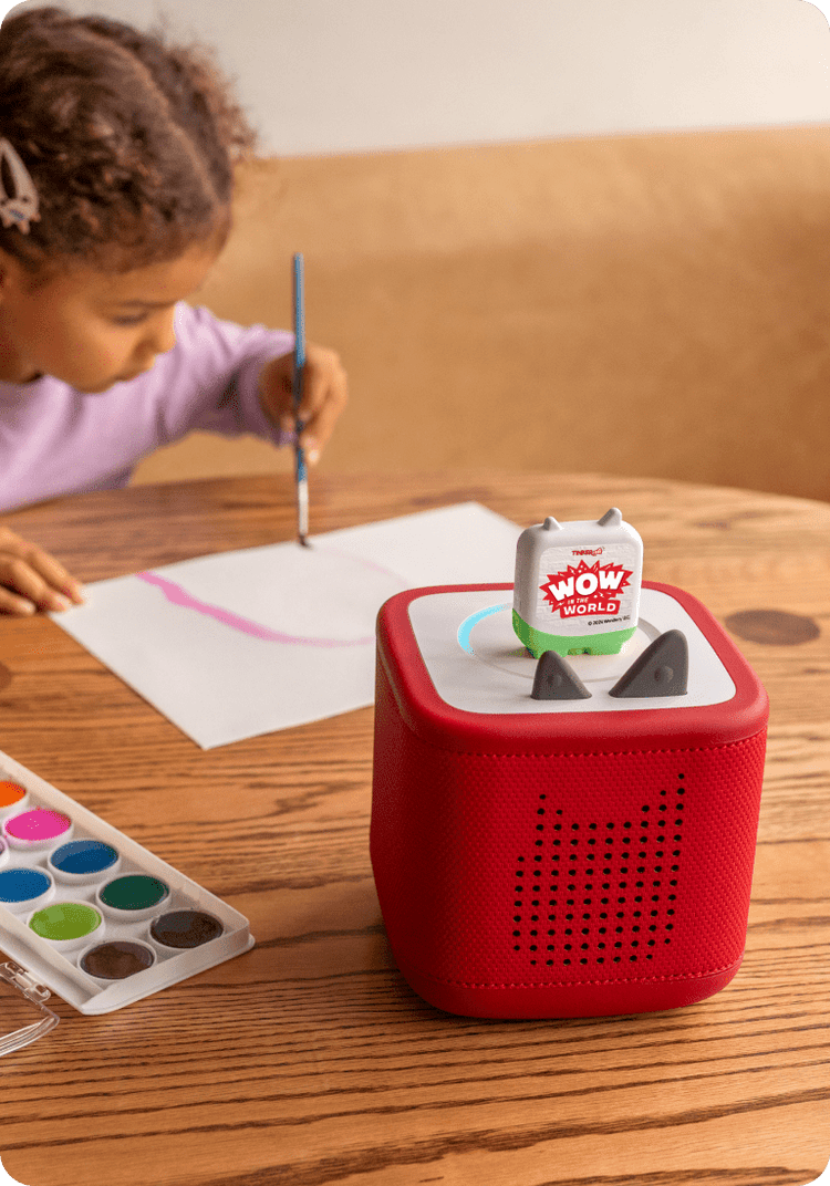 child enjoying craft time while listening to wow in the world tonie on a red toniebox 2
