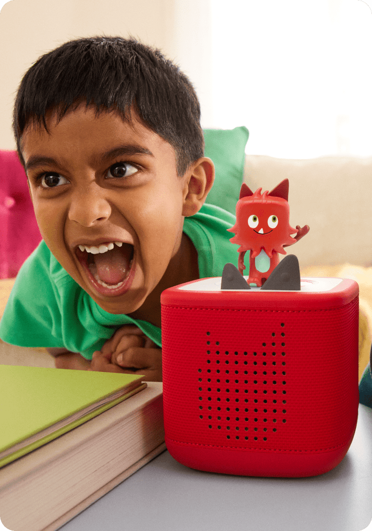 child listening to monster creative tonie on a red toniebox 2