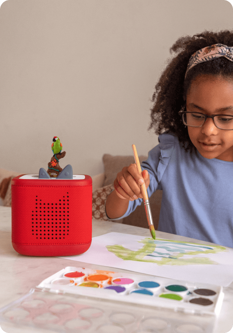 child enjoying craft time while listening to rainforest tonie on a red toniebox 2