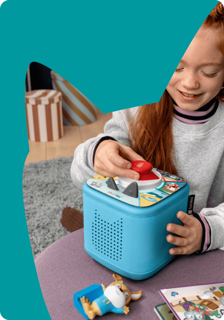 child playing Tonieplay game with controller and blue toniebox 2