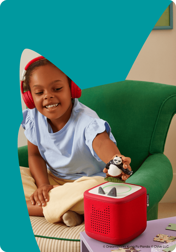 child wearing tonies red bluetooth headphones listening to Kung Foo Panda Tonie on a red Toniebox 2