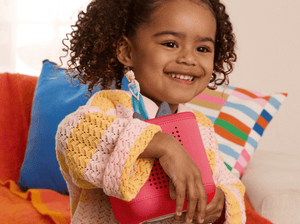 Child playing with Sam's Club Toniebox 2 Disney Bundle - Sunset Red audio figurine and Toniebox 2