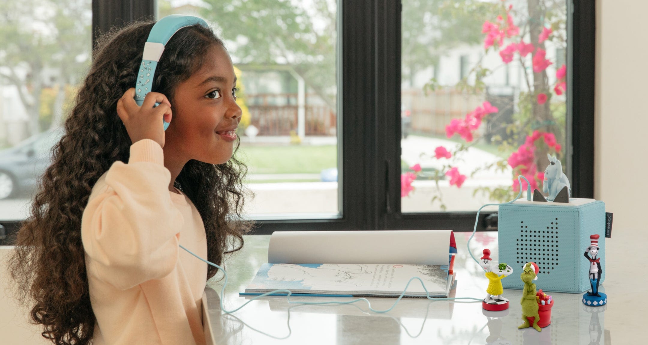 Girl listening to a collection of Dr Seuss Tonies with headphones for kids