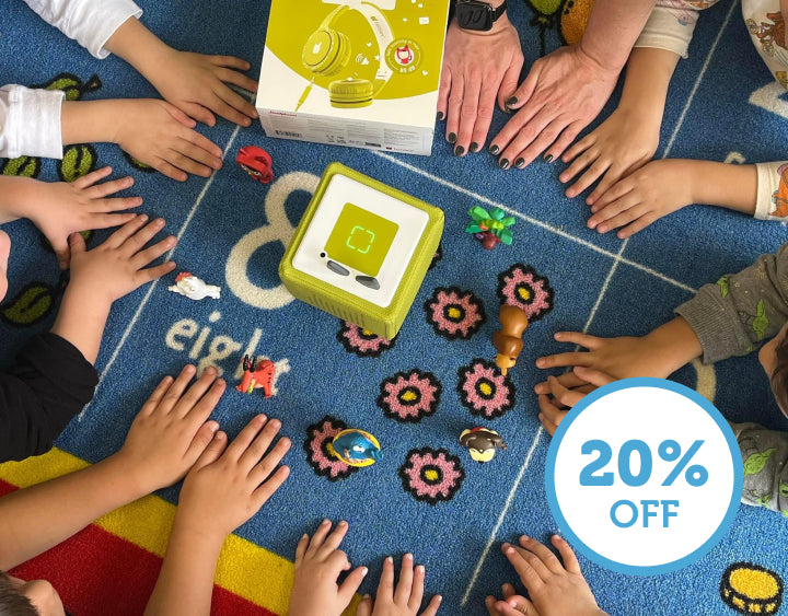 children playing in a classroom with a green Toniebox. Teachers and Military save 20% off orders.