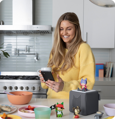 Mom in the kitchen downloading content from the tonies app to Creative Tonies to start the day