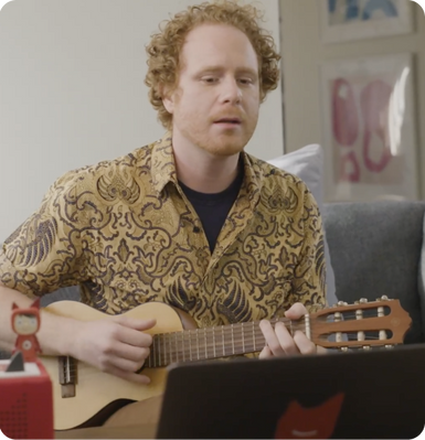 Man using a ukulele to create music for a creative tonie.