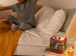 Child playing near a Jurassic Park Sleeve on a red Toniebox 2