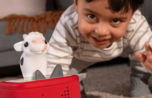 young child listening to a red Toniebox 2 with My First Cow Tonie