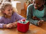 Kids playing with a red toniebox 2 and mystery mavericks toniplay