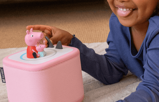 child playing on the floor with a pink Toniebox 2 and Peppa Pig Tonie