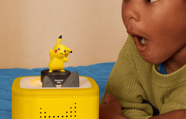 child listening to the Pikachu Tonie on a yellow limited edition Toniebox 2