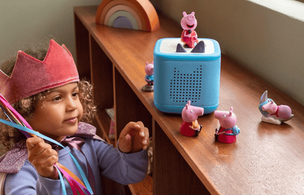 child playing dressup with a crown on listening to Peppa Pig Tonie on a blue Toniebox 2