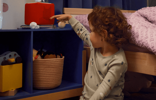 sleepy friend Tonie with a red Toniebox helping a child get ready for bed without a screen