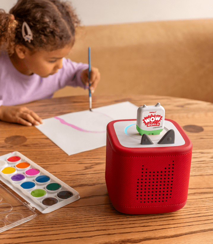 girl painting while listening to WoW in the World Tonie on a red Toniebox 2