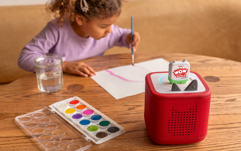 girl painting while listening to WoW in the World Tonie on a red Toniebox 2
