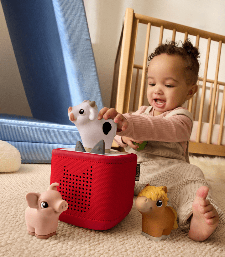 little child playing with the My First Tonie farm set and red Toniebox 2