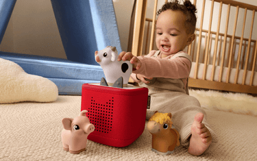 little child playing with the My First Tonie farm set and red Toniebox 2