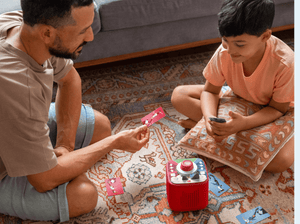 man and child playing with Tonieplay-Stadium Showdown and a red toniebox 2