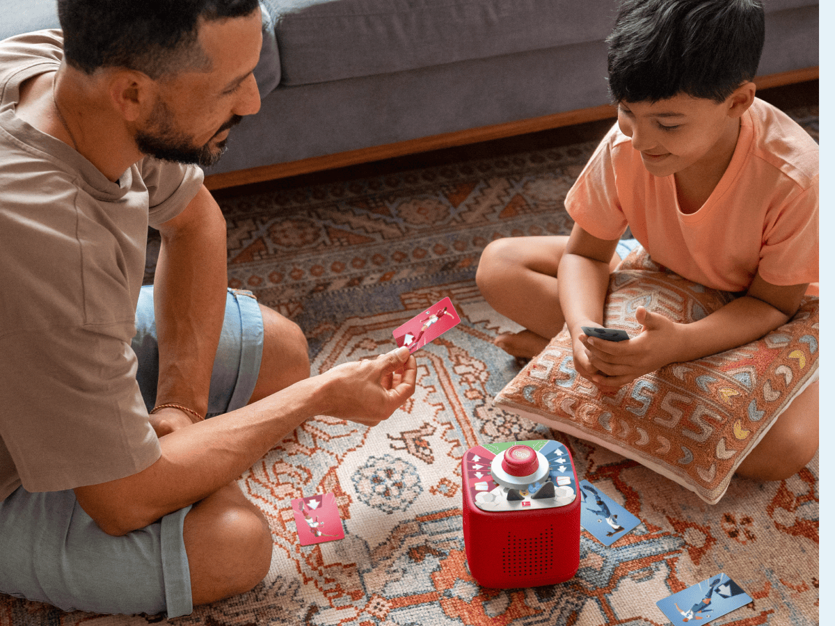 man and child playing with Tonieplay-Stadium Showdown and a red toniebox 2