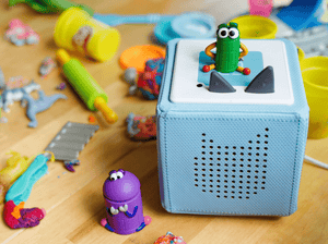 Child playing with Ask the StoryBots: Beep Tonie audio figurine and Toniebox 2
