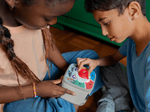 Kids playing with a red toniebox 2 and time academy toniplay