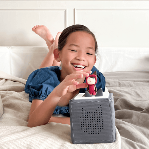 child playing with a creative-tonie and gray toniebox