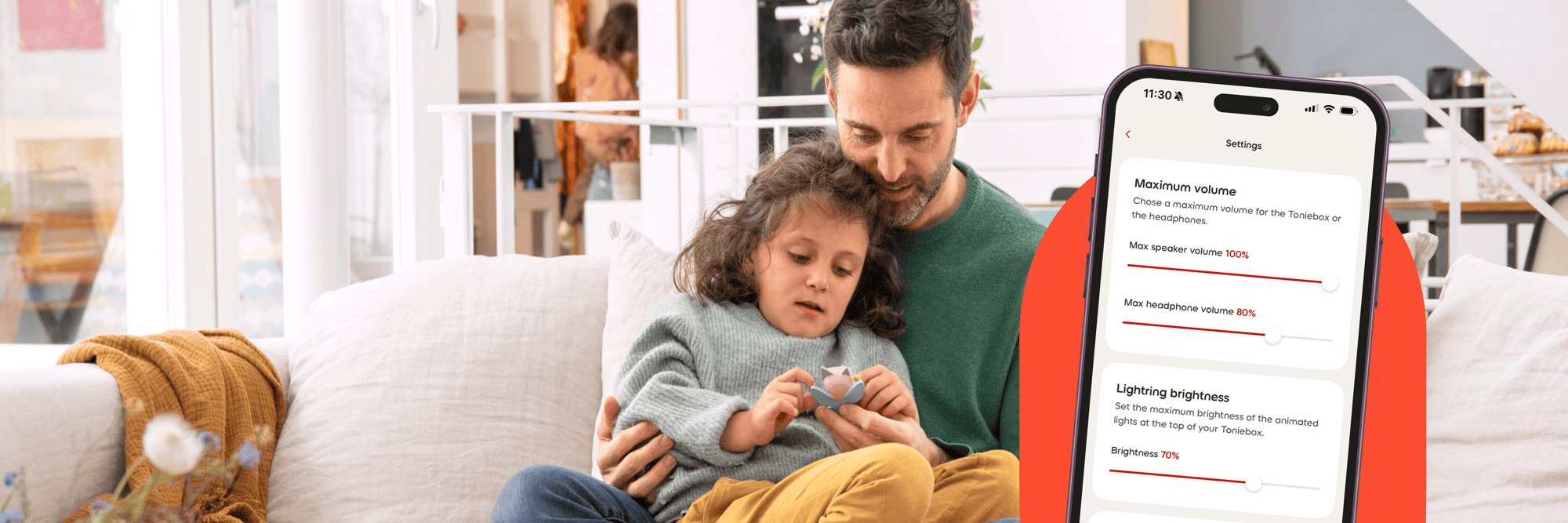 Dad and child sitting on the couch looking at the Fairy Creative Tonie with the tonies app overlay