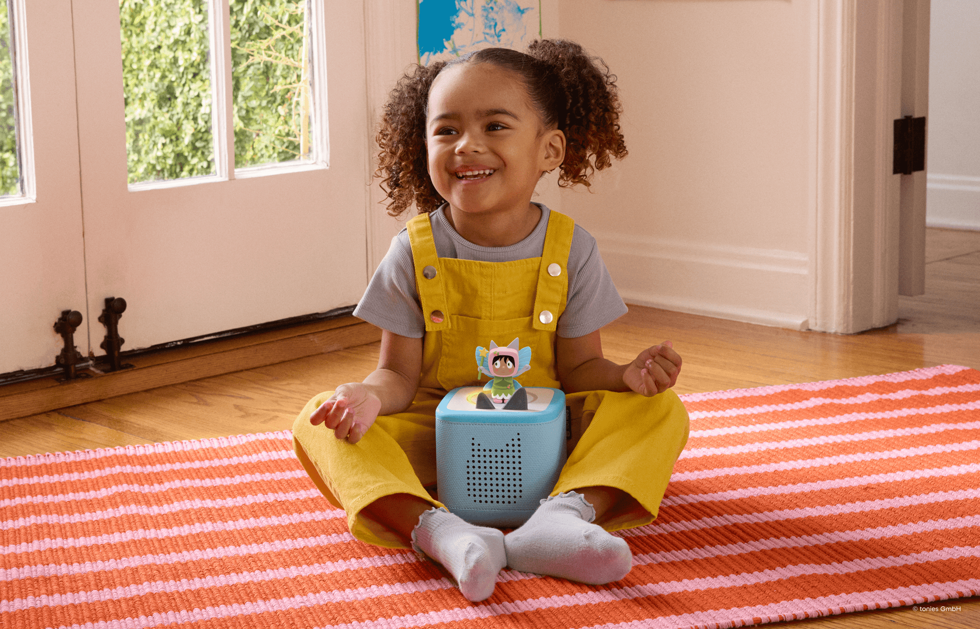 child playing with a blue toniebox 2 and fairy creative tonie