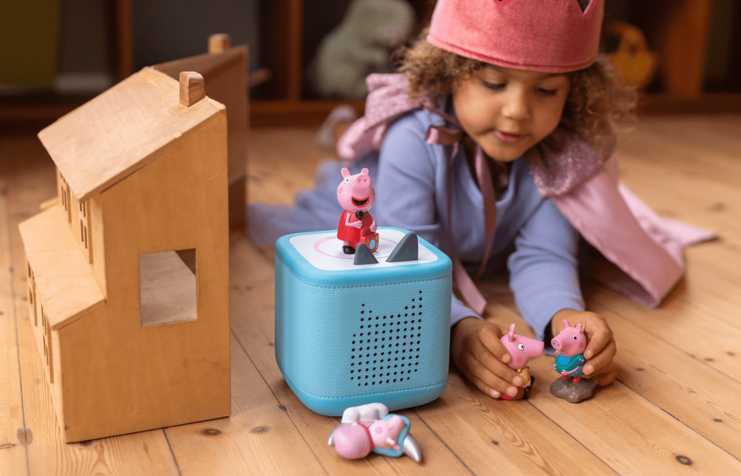 child playing with Peppa Pig Tonies while listening to a blue Toniebox 2