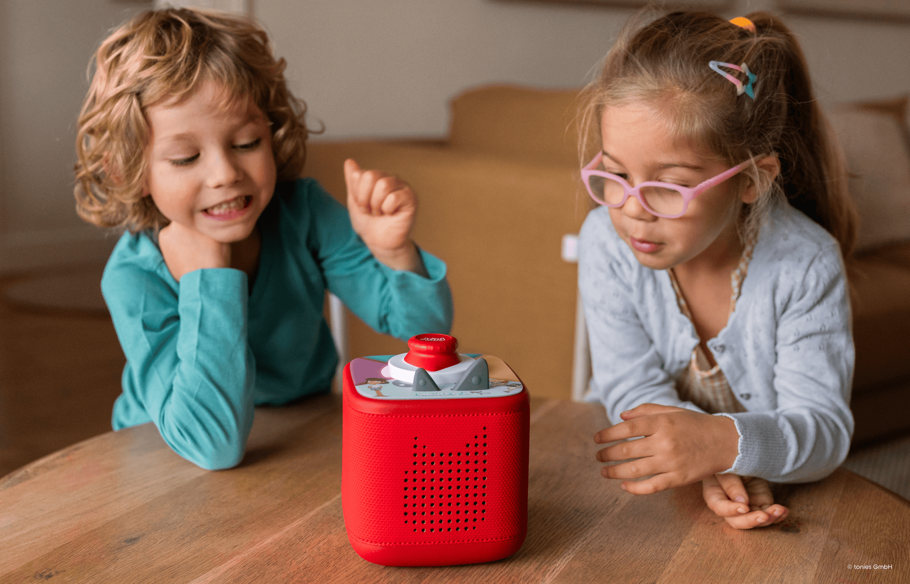 two kids playing a Tonieplay game on a red Toniebox 2
