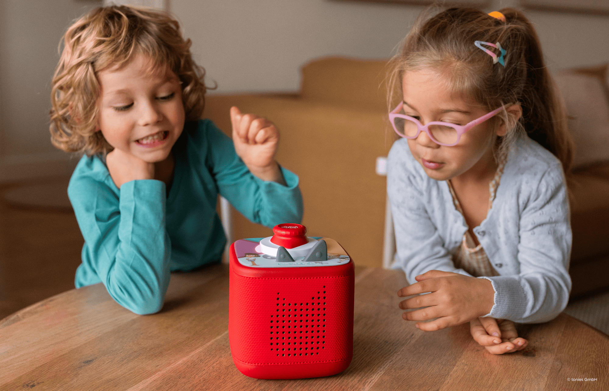 two kids playing a Tonieplay game on a red Toniebox 2