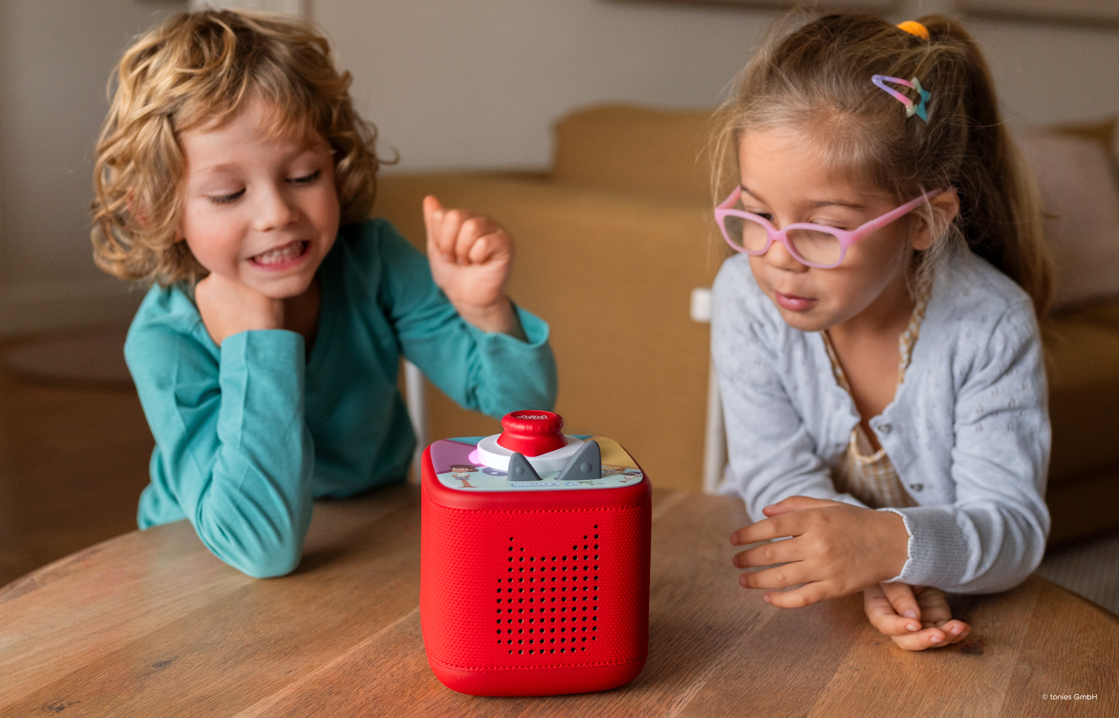 two kids playing a Tonieplay game on a red Toniebox 2