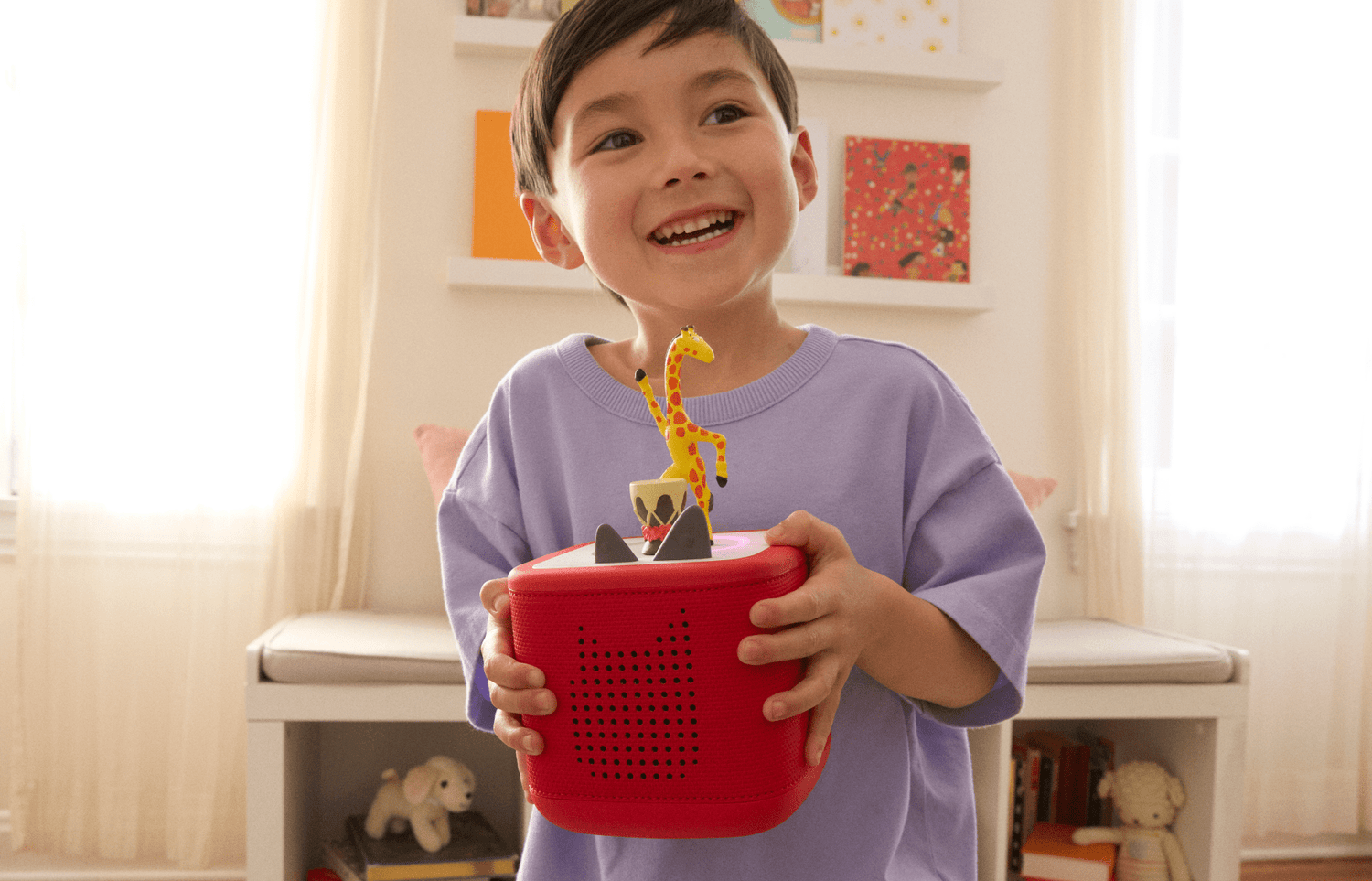 child listening to Giraffes Can't Dance Tonie on a red Toniebox 2